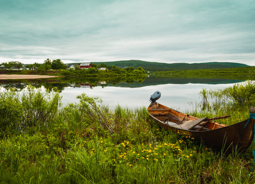A wooden boat on a Kárášjohka river bank in Karasjok, Norway