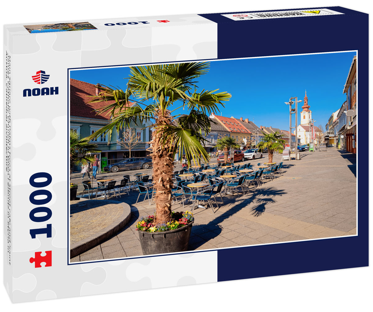 Main square with Palms trees at street cafe and Saint James Catholic Church in town Leibnitz in Styria in Austria. Cathedral architecture