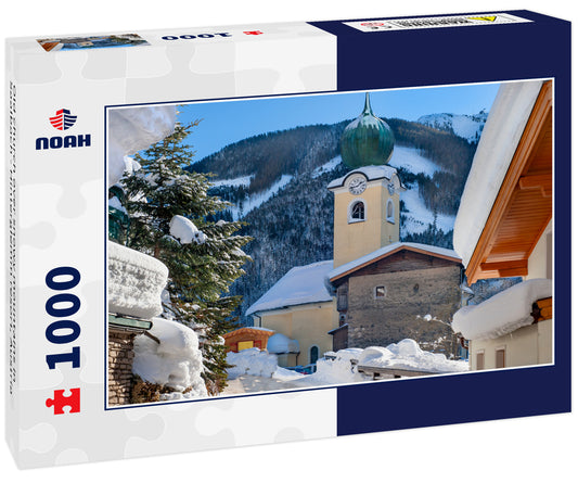 Old church over snowy mountains in Saalbach - Hinterglemm resort, Austria