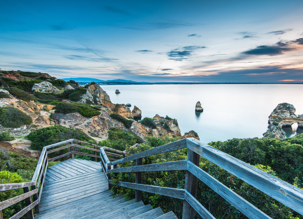 Wooden footbridge walkway to beautiful beach Praia do Camilo on coast of Algarve region, Portugal