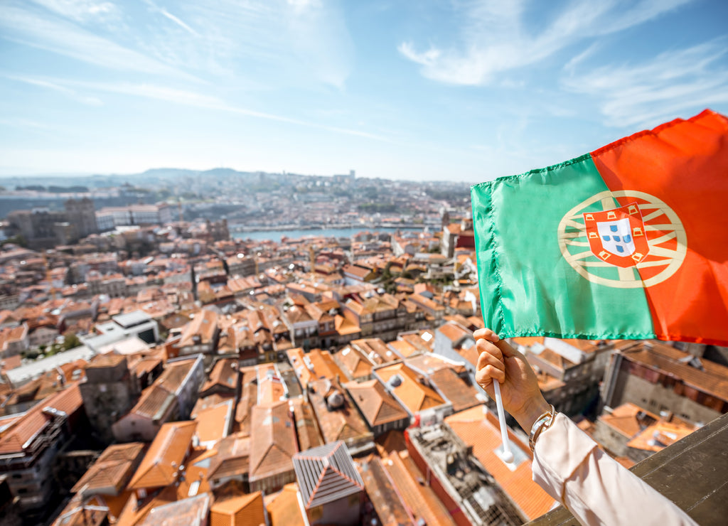 Aerial cityscape view on the old town with Portuguese flag in Porto, Portugal