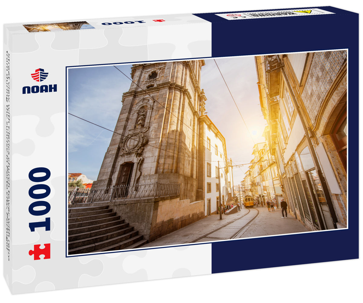 Street view with Clerics church tower with retro tram during the sunrise in Porto city, Portugal