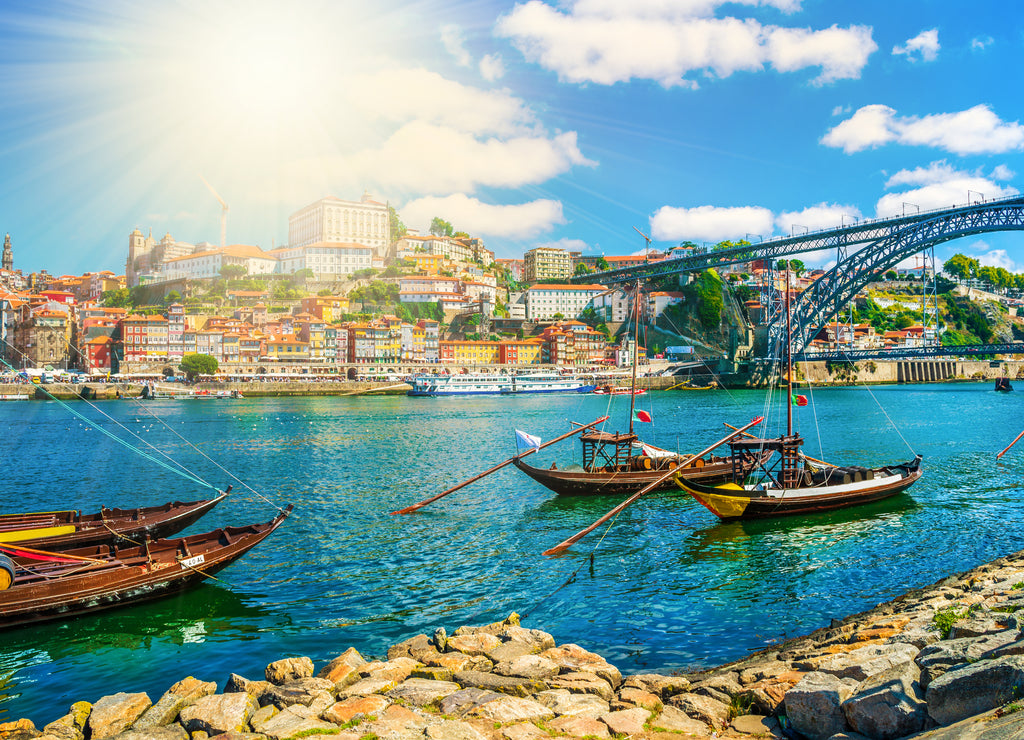 Dom Luis I bridge and traditional boats on Rio Douro river in Porto, Portugal