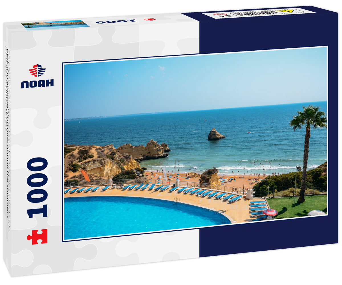 Empty swimming pool overlooking Cova Redonda Beach in Algarve, Portugal during the summer - paradise holiday theme