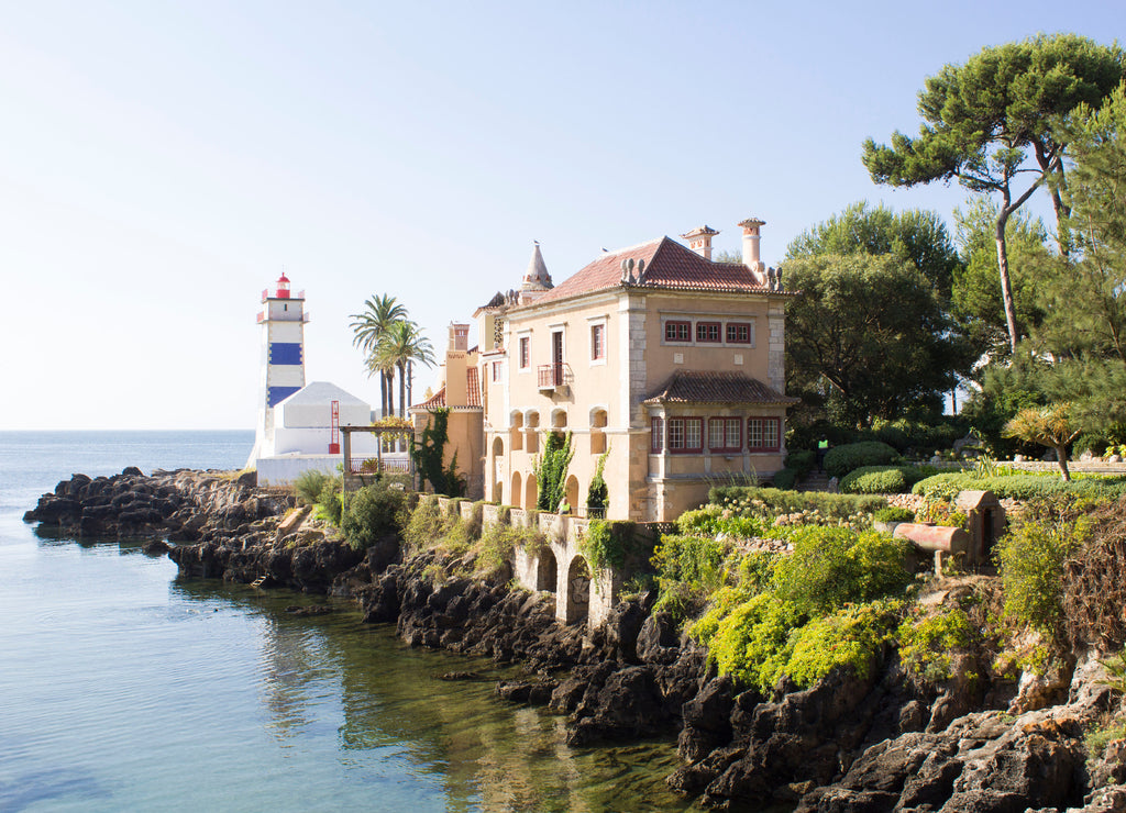 Beautiful view of the beach, lighthouse and villa on the sunny day. Cascais. Portugal