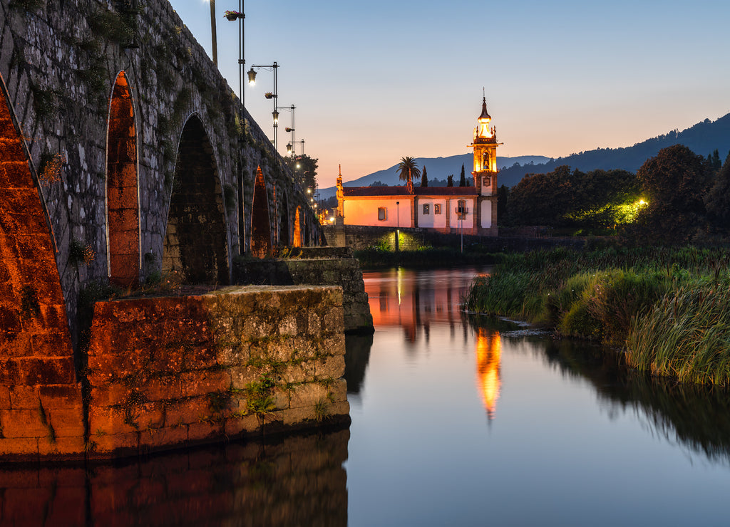 Church at the end of the Roman bridge of Ponte de Lima, in Minho, Portugal. Blue hour.