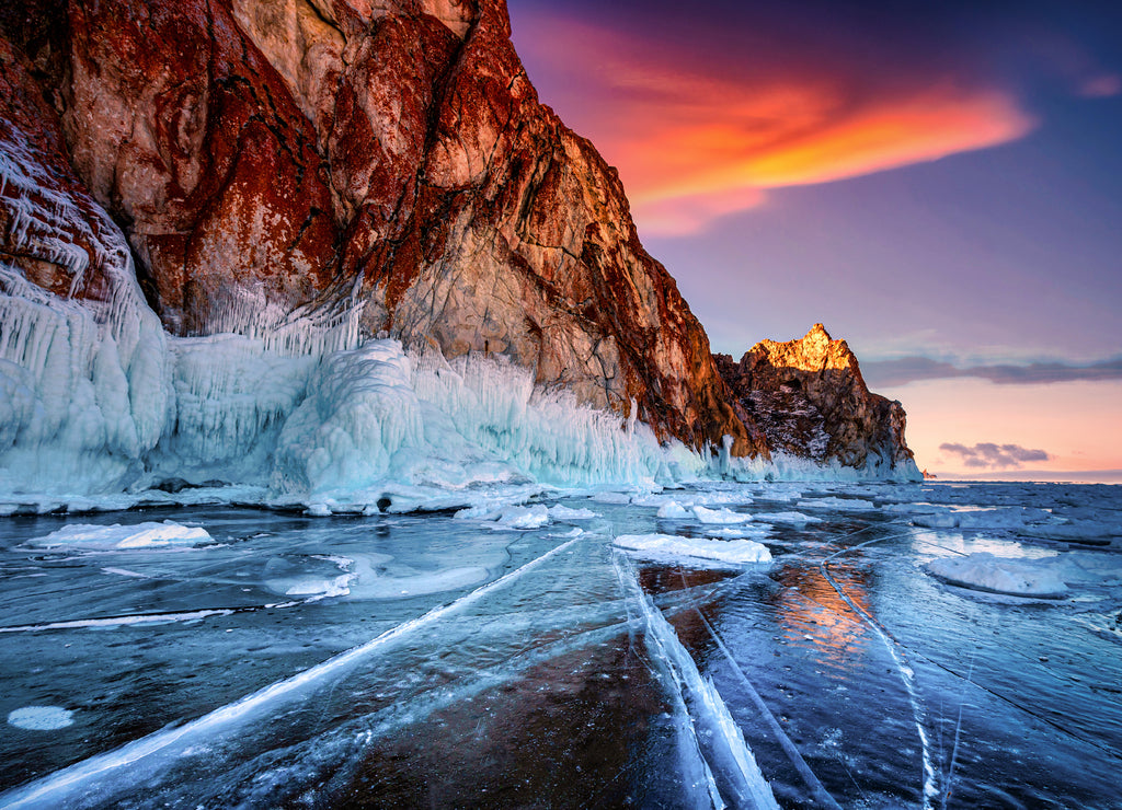 Landscape of Mountain at sunset with natural breaking ice in frozen water on Lake Baikal, Siberia, Russia