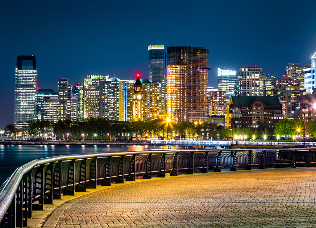 Jersey City skyline by night along Hudson river promenade, New Jersey