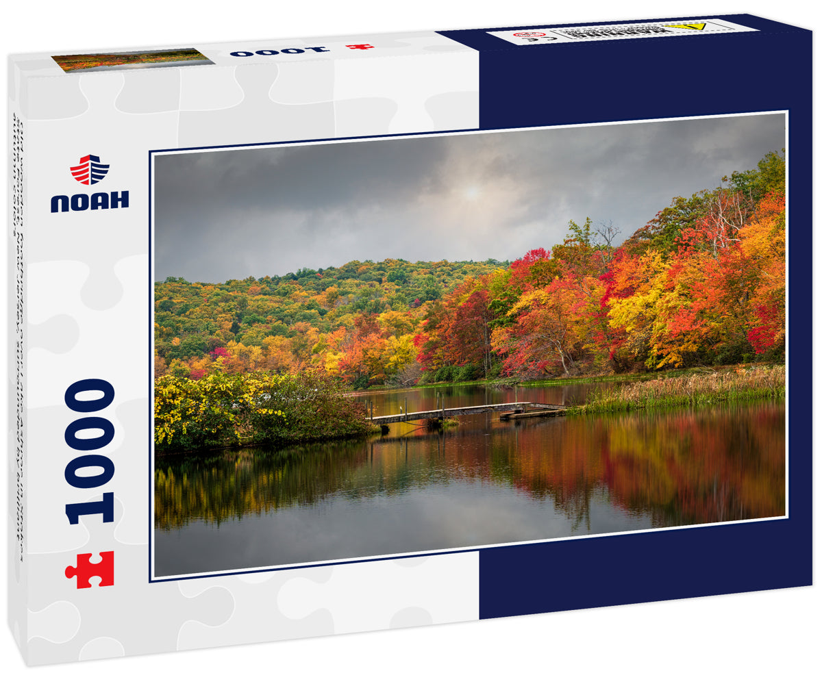 Old wooden footbridge over Lake Ashroe in Stokes State Forest, New Jersey, surrounded by brilliant autumn colors