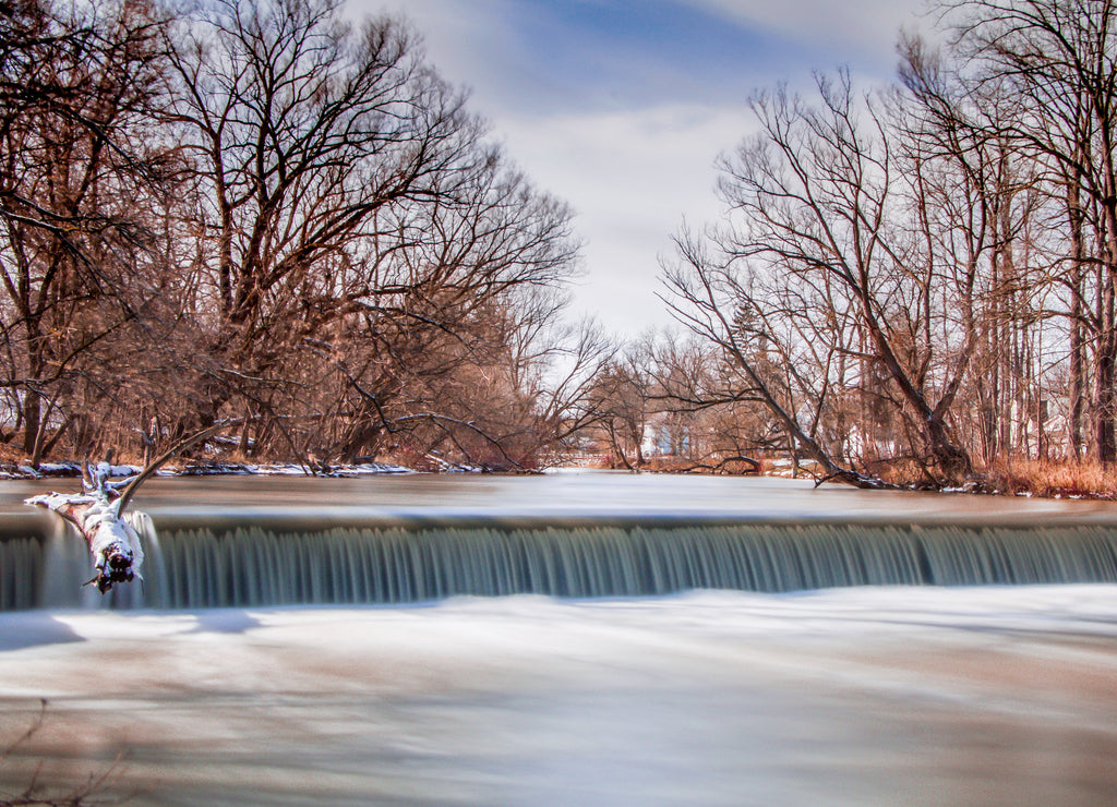Waterfall and felled log with blue sky background, Batavia New York,Genesee County