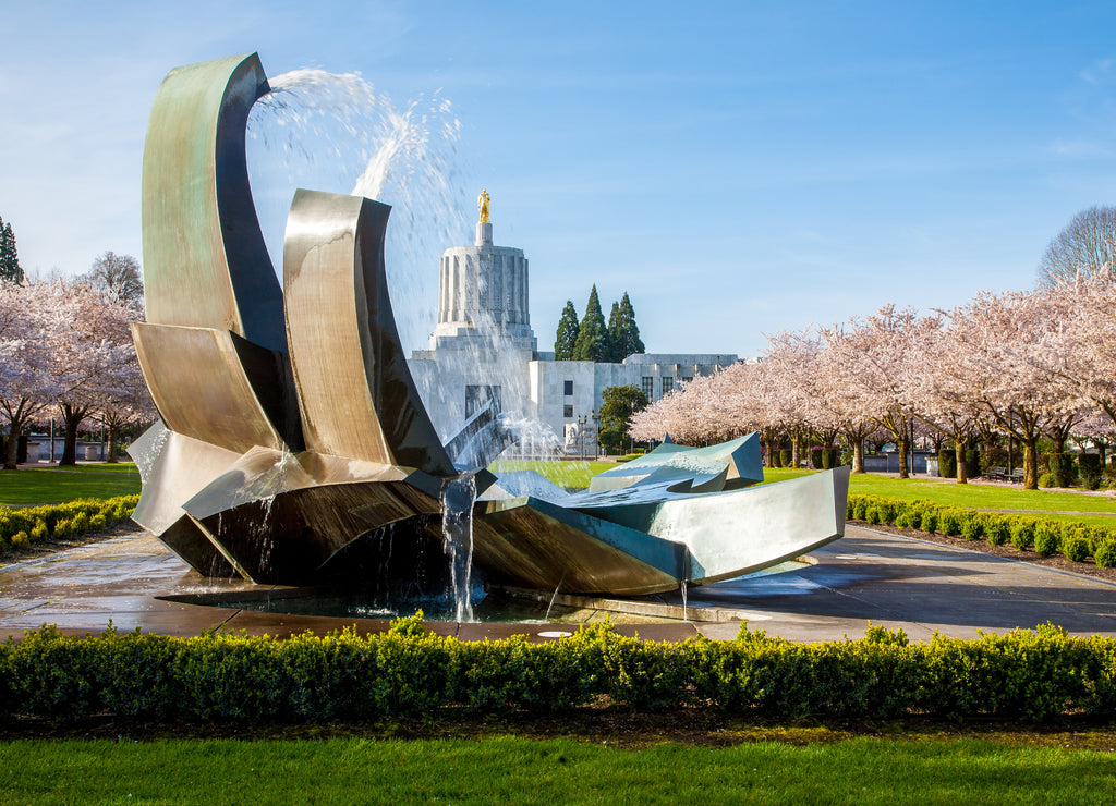 The Oregon State Capitol building in Salem with flowering cherry trees in bloom