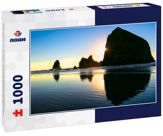 Silhouette of famous sea stack rock formations with natural sun flare. Cannon Beach, Oregon USA