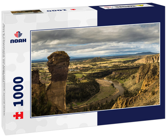 Rock climbers on top of rock spire with vast landscape in Oregon