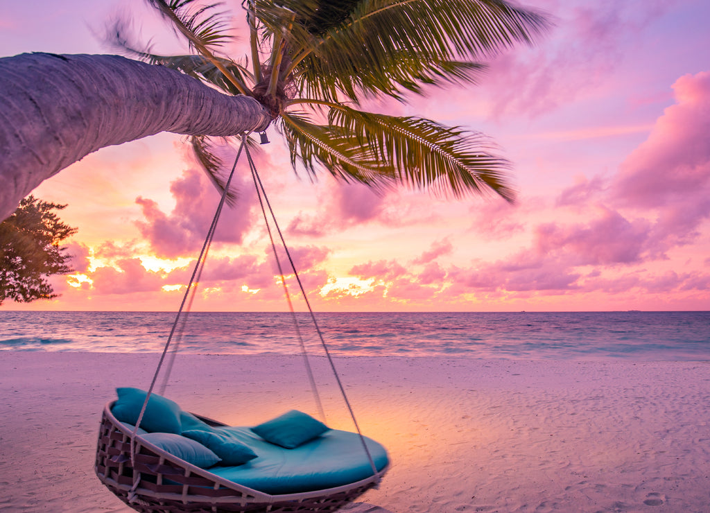 Tropical sunset beach background as summer landscape panorama with beach swing or hammock and white sand and calm sea beach banner Hawaii