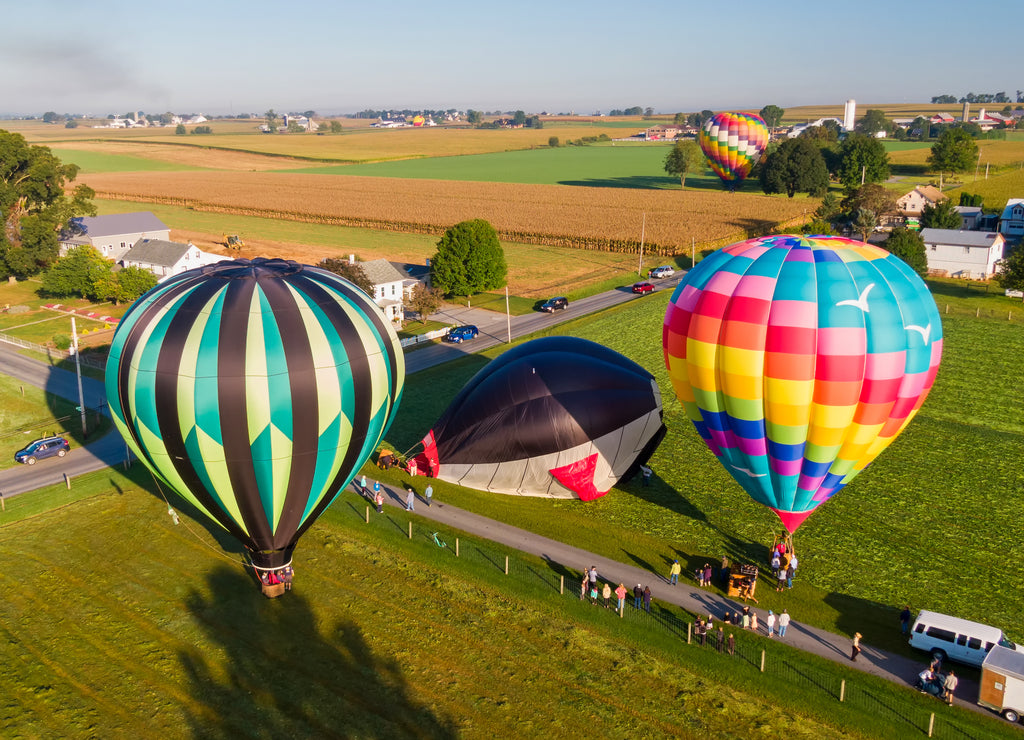 Hot air balloons rise into the air above American countryside in Pennsylvania