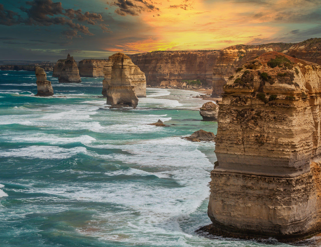 Noah Jigsaw Puzzle Blue green ocean and beach with sandbanks cliffs and waves with close view of The twelve apostles and cliffs in the shadow of the sunset in Victoria, Australia against a orange cloudy sky 1000 pieces