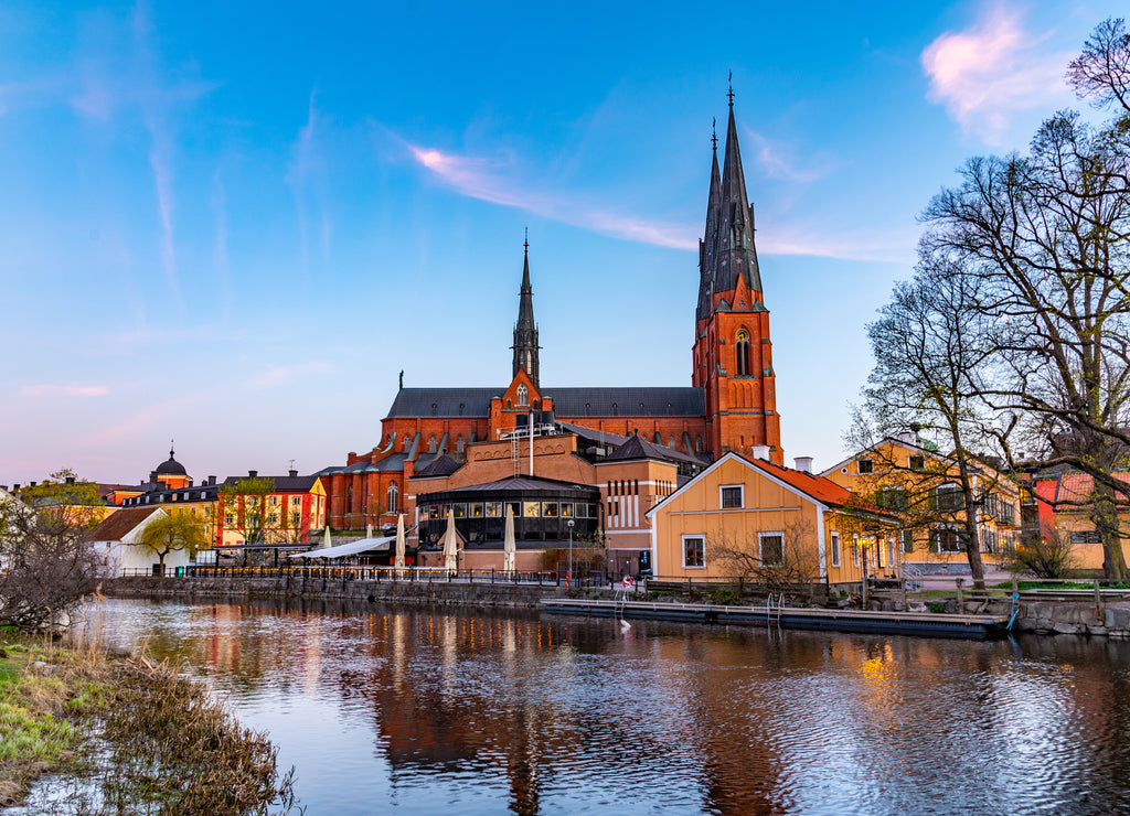 Sunset view of Uppsala cathedral reflecting on river Fyris in Sweden