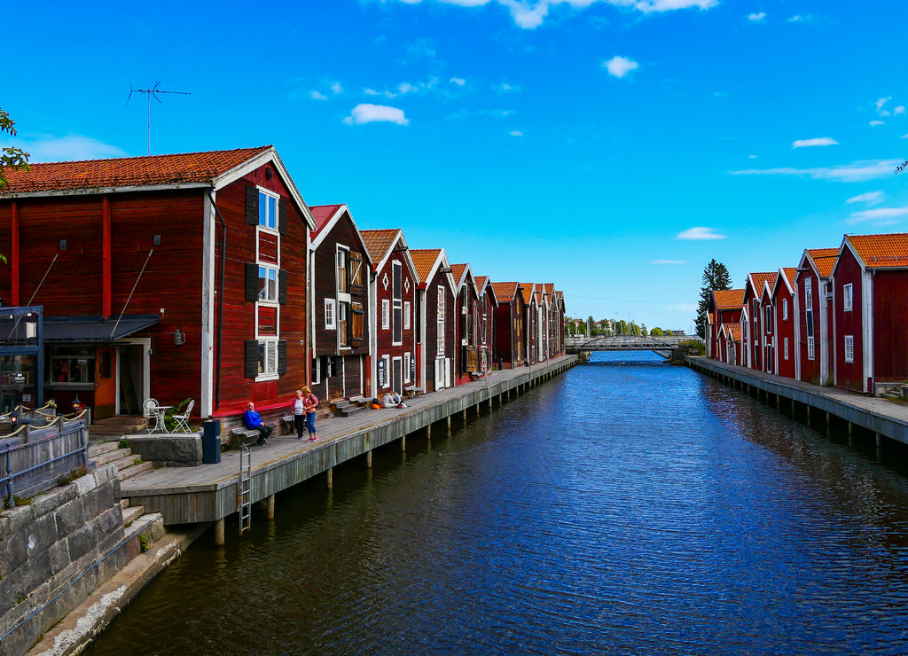 Hudiksvall, Sweden People sitting among old fishermen boathouses on the Sundskanalen, or Sund Canal, also known as Moljen