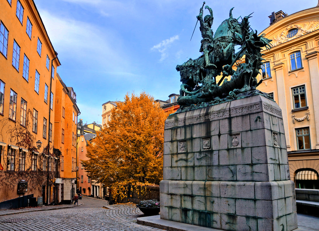 Saint George and the Dragon statue and colorful street during autumn in Gamla Stan, the Old Town of Stockholm, Sweden
