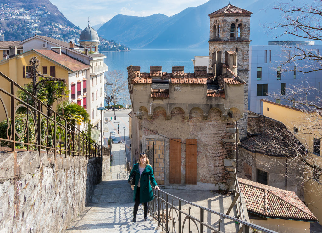 A young woman standing in front of an old architecture building in the city of Lugano, Switzerland