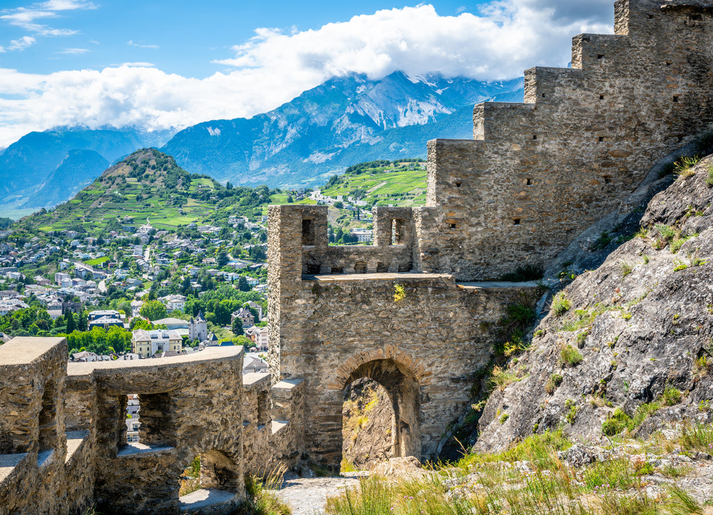 Entrance door and wall of the ruins of Tourbillon castle and Sion hill and city panorama in background Sion Valais Switzerland
