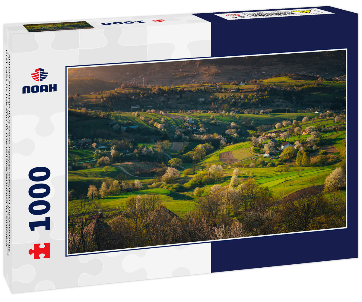 Spring sunrise in a rural landscape with blossoming cherries and bright green fields and small houses. The first rays of the sun in the village Hrinova in Slovakia