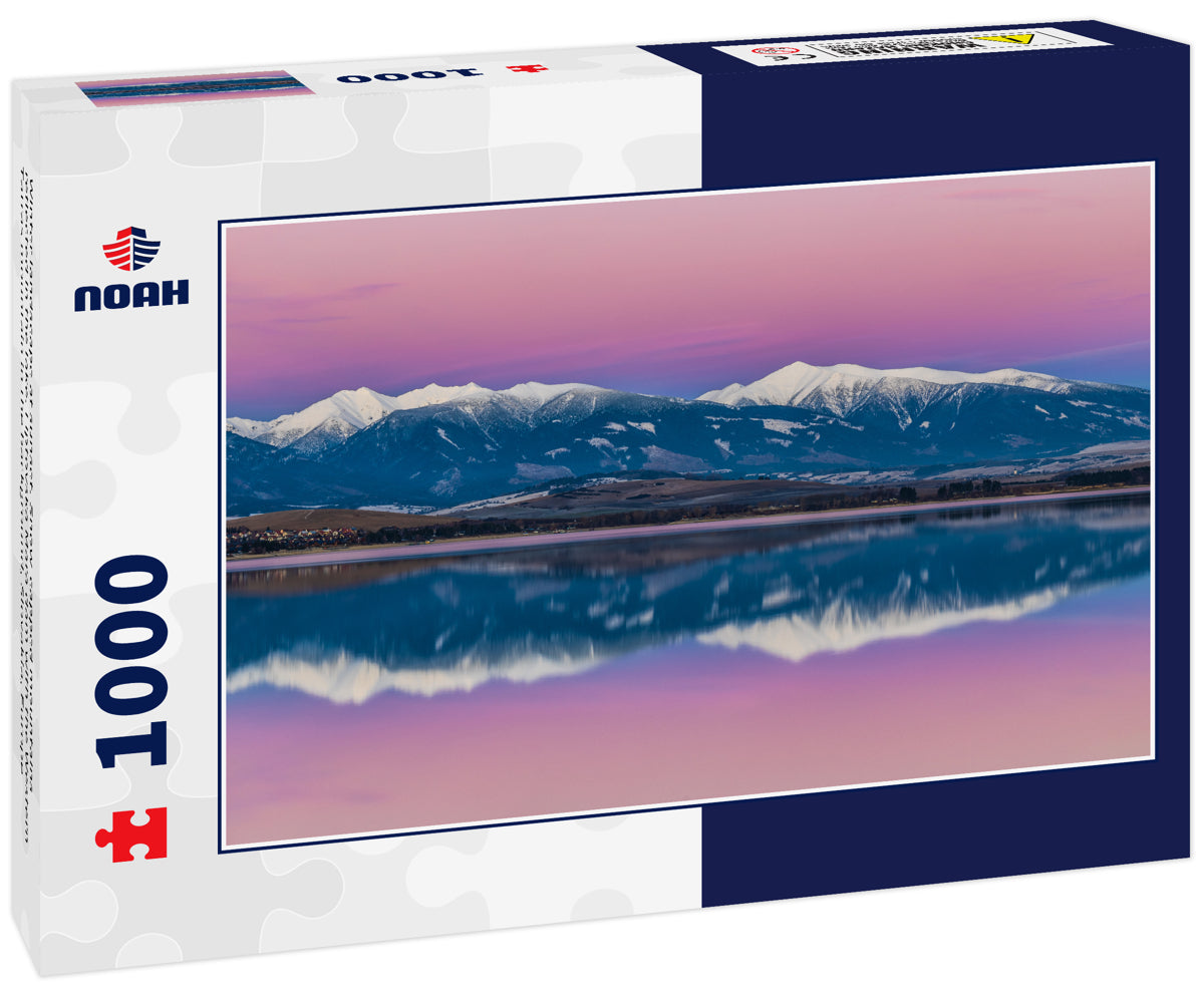 Winter landscape at sunset. Snow-capped mountains reflected in the lake. Liptovska Mara dam with the Western Tatras mountain in the background, Slovakia, Europe