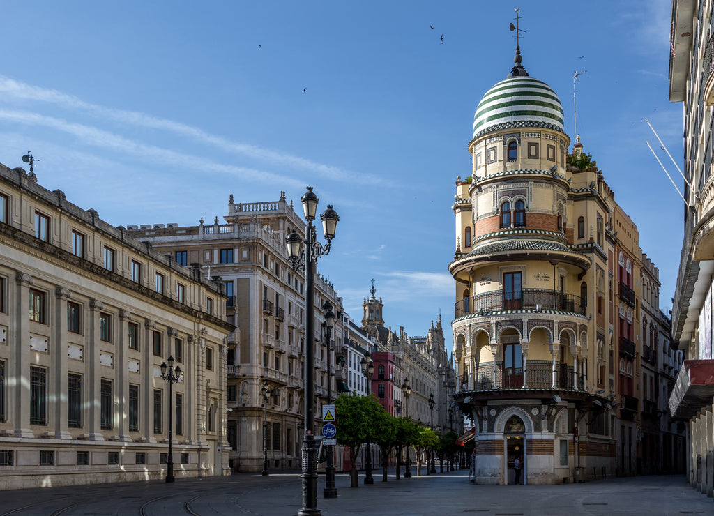The 'Avenida de la Constitucion' in Seville just after sunrise, with the lovely "Confiteria Filella" tower , the 'Banco de España' and the Cathedral