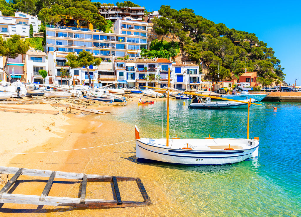 Traditional white fishing boat on beach in Llafranc port, Costa Brava, Spain
