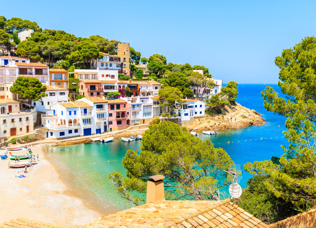 View of beach in Sa Tuna fishing village with colorful houses on shore, Costa Brava, Catalonia, Spain
