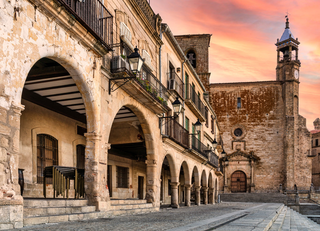 view of the arches and church from the main square of Trujillo, Extremadura, Spain - sunset sky