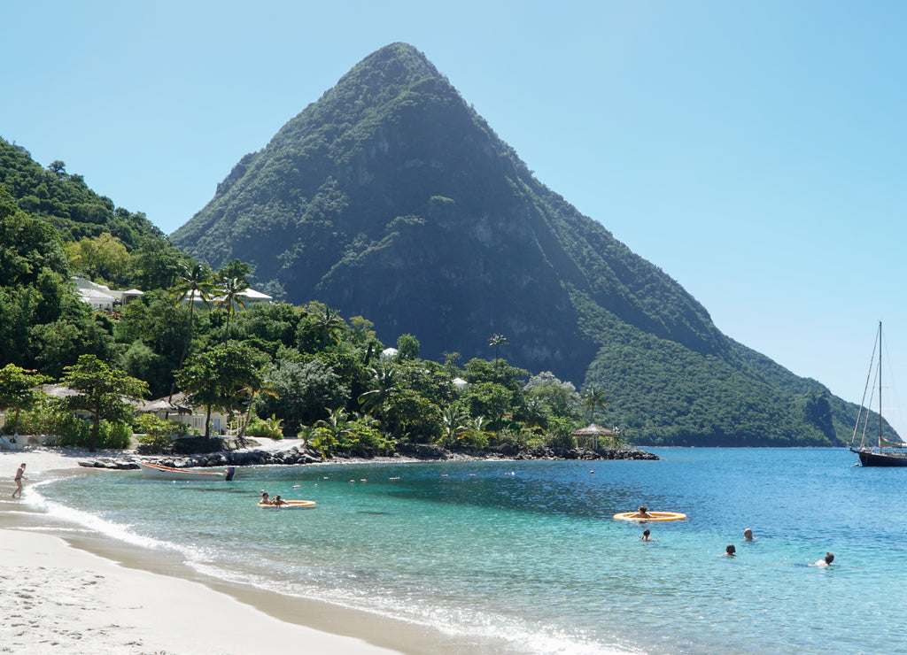 The Piton mountains Gros Piton and Petit Piton in a lush green forest next to the blue ocean on Saint Lucia Island in the Caribbean Sea
