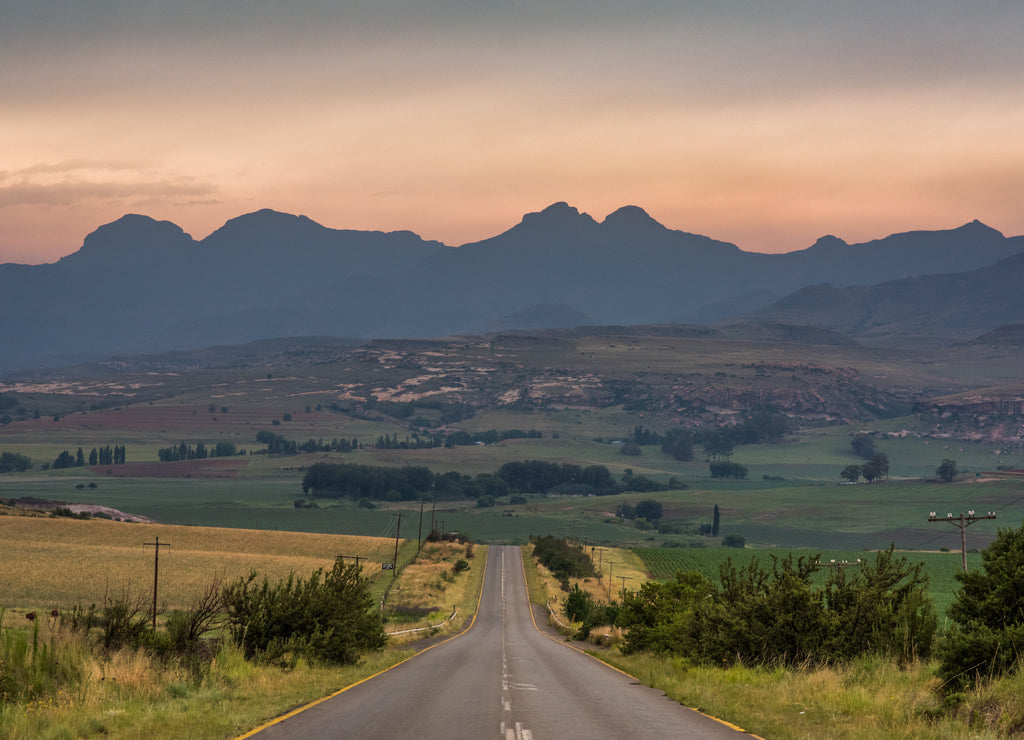 A road leading towards the Drakensberg mountains at sunrise near Clarens, South Africa