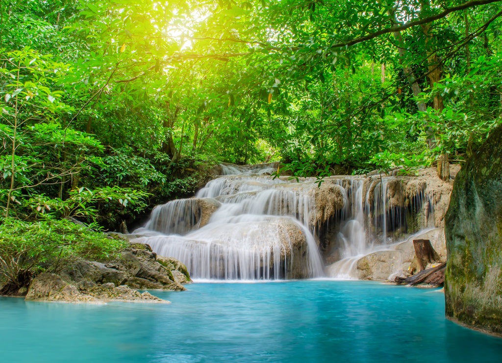 Deep forest waterfall at Erawan waterfall, beautiful waterfall with sunlight rays in deep forest, Erawan National Park in Kanchanaburi, Thailand