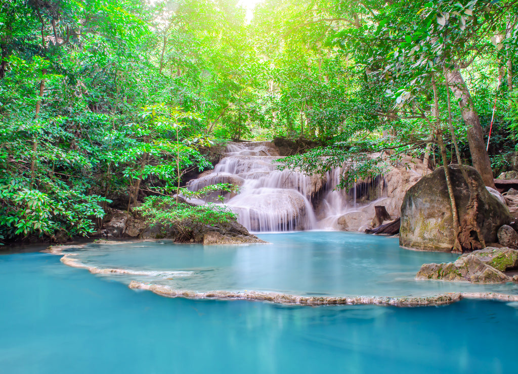 Deep forest waterfall at Erawan waterfall, beautiful waterfall with sunlight rays in deep forest, Erawan National Park in Kanchanaburi