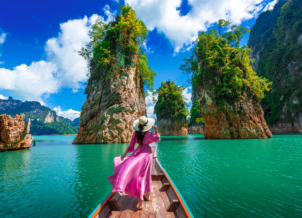 Asian woman posing on boat in Ratchaprapha dam Khao sok national park at suratthani, Thailand