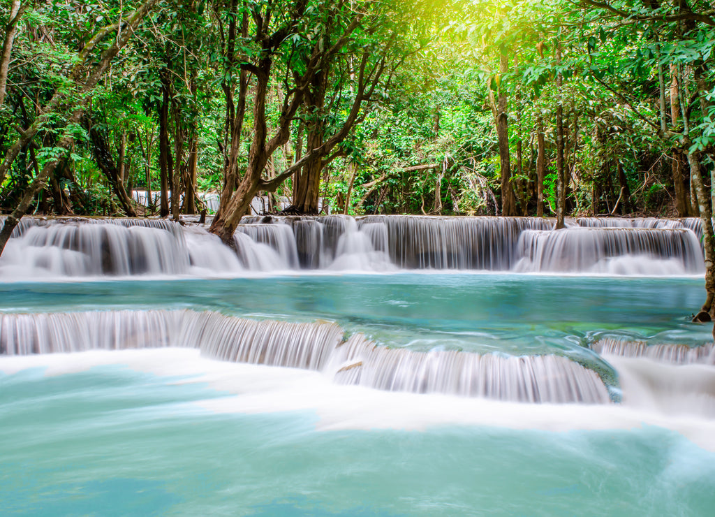 Travel to the beautiful waterfall in tropical rain forest, soft water of the stream in the natural park at Kanchanaburi