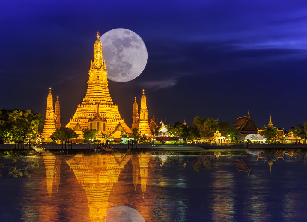 Wat arun in night with super full moon,Wat Arun at night with Light gold is the oldest temple of the Chao Phraya River and Full moon In the dark sky in Bangkok Thailand