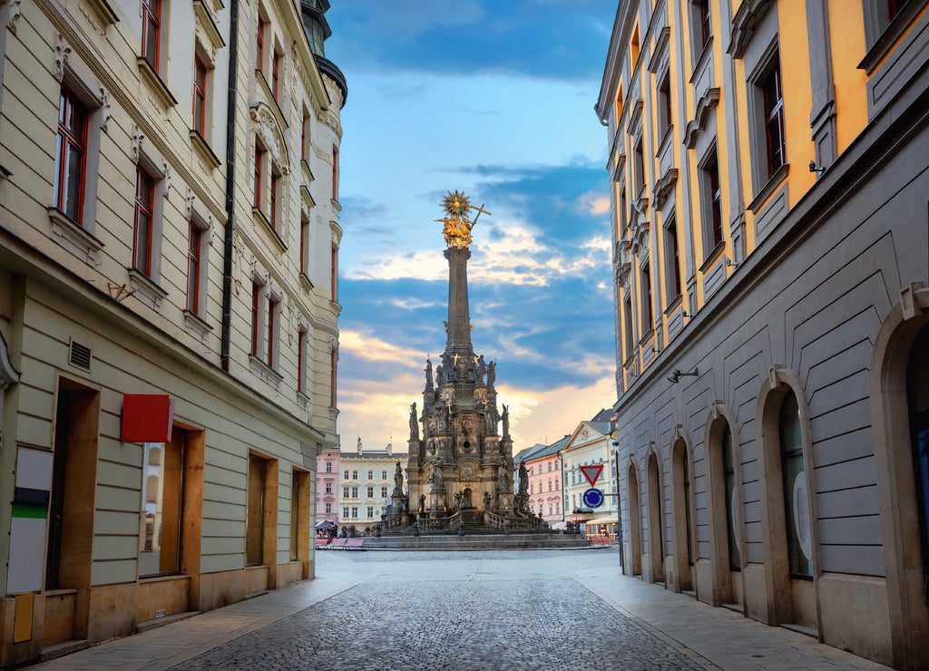 Street in centre city with view to square and monument of Holy Trinity Column. Olomouc, Czech Republic