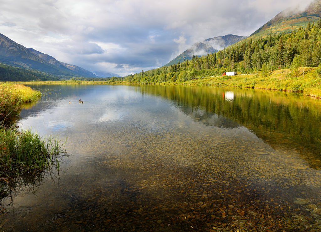 Beautiful sunrise at Kenai River with forest and reflection in the water, Alaska, USA