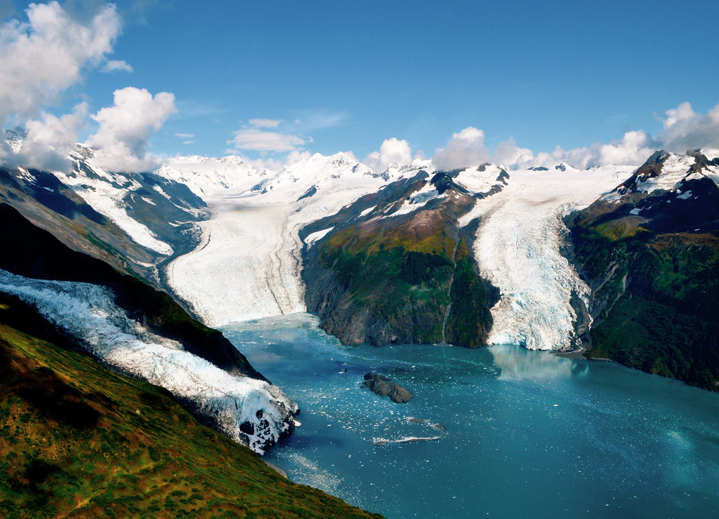 Aerial shot of three majestic glaciers calving into the beautiful azure blue waters of Prince William Sound, Alaska