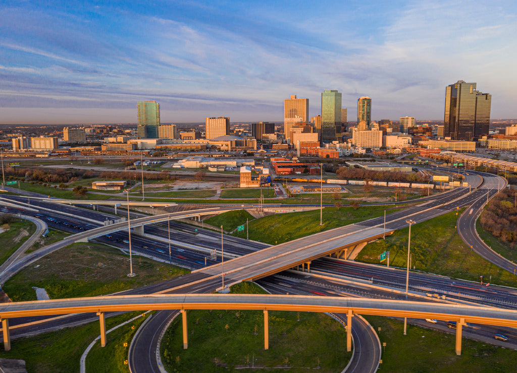 Aerial panorama picture of the Fort Worth skyline at sunrise with highway intersection in Texas