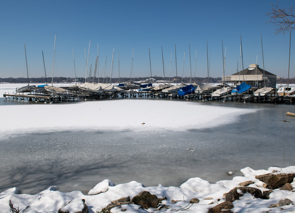 A scene of White Rock Lake in Dallas Texas with sailboats in view after a hard freeze and snow storm in February 2021