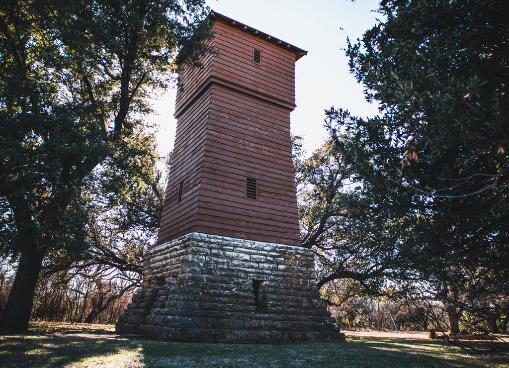 Historic water tower from the 1930s in a wooded area in the Abilene State Park in Texas, USA