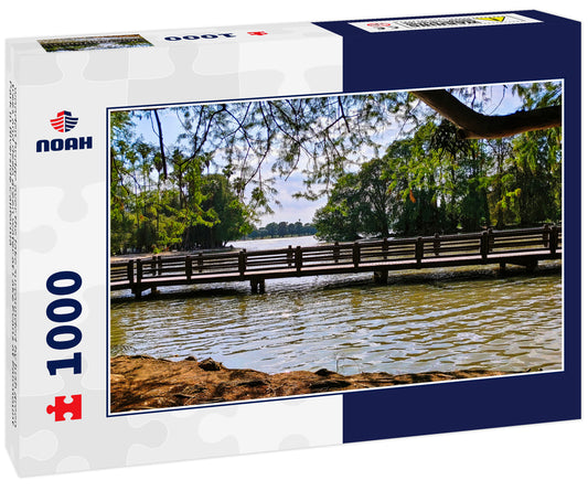 wooden bridge over the lake surrounded by lush green trees and deep green water at Lake Evans at Fairmount Park in Riverside California