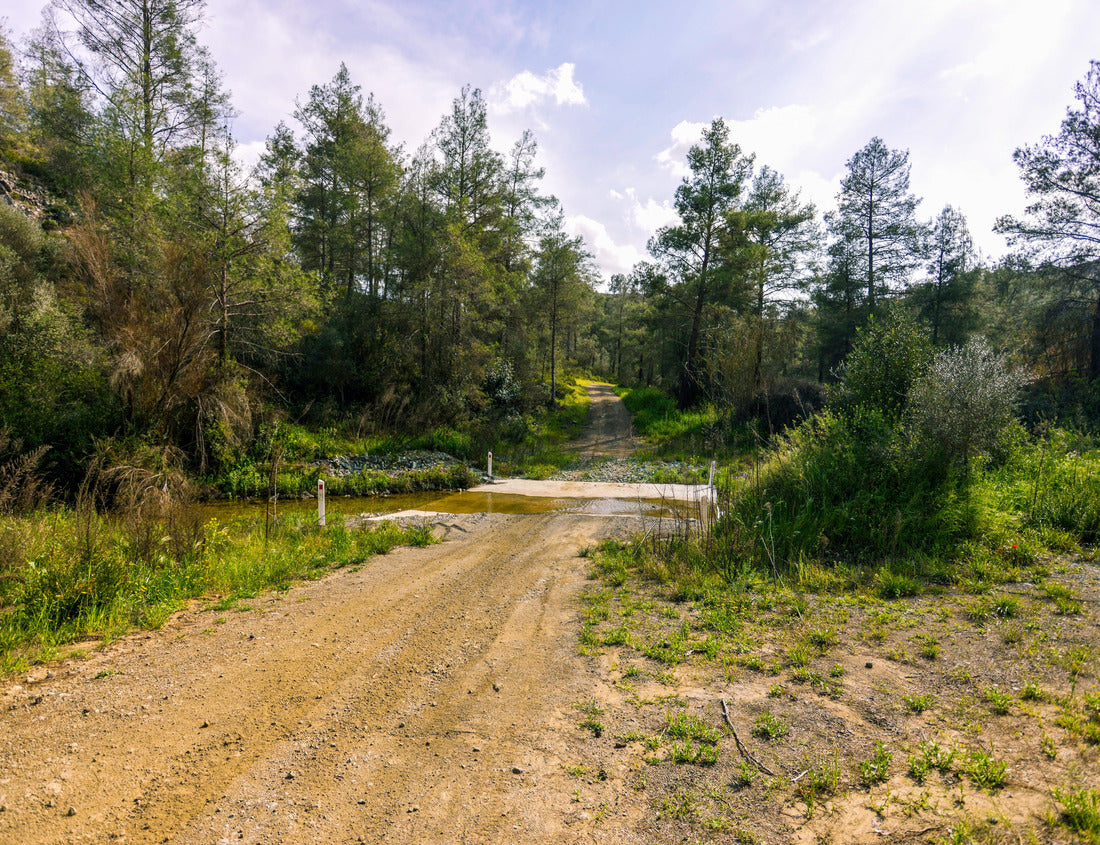 Noah Jigsaw Puzzle A dirt road crosses the river Vathy Argaki Through a ford and climbs a hill surrounded by rocks, green bushes and pine forest and under a blue cloudy sky (Kornos, Larnaca District, Cyprus) 1000 pieces
