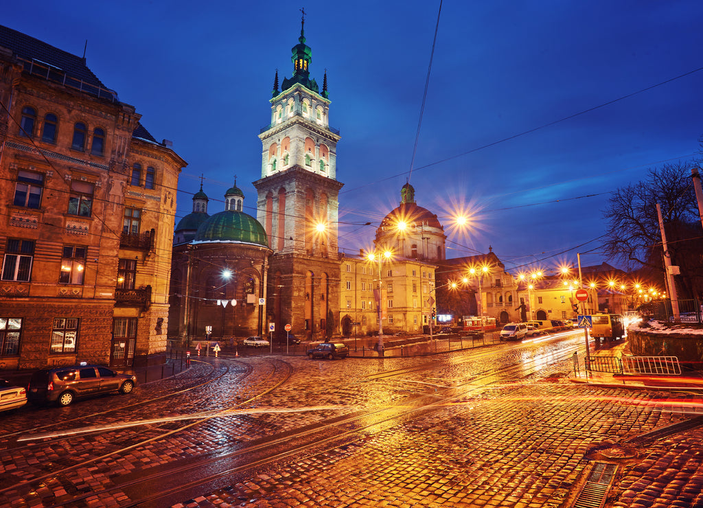Scenic view on illuminated Assumption Church Bell Tower at twilight with vintage tram on foreground, Lviv, Ukraine