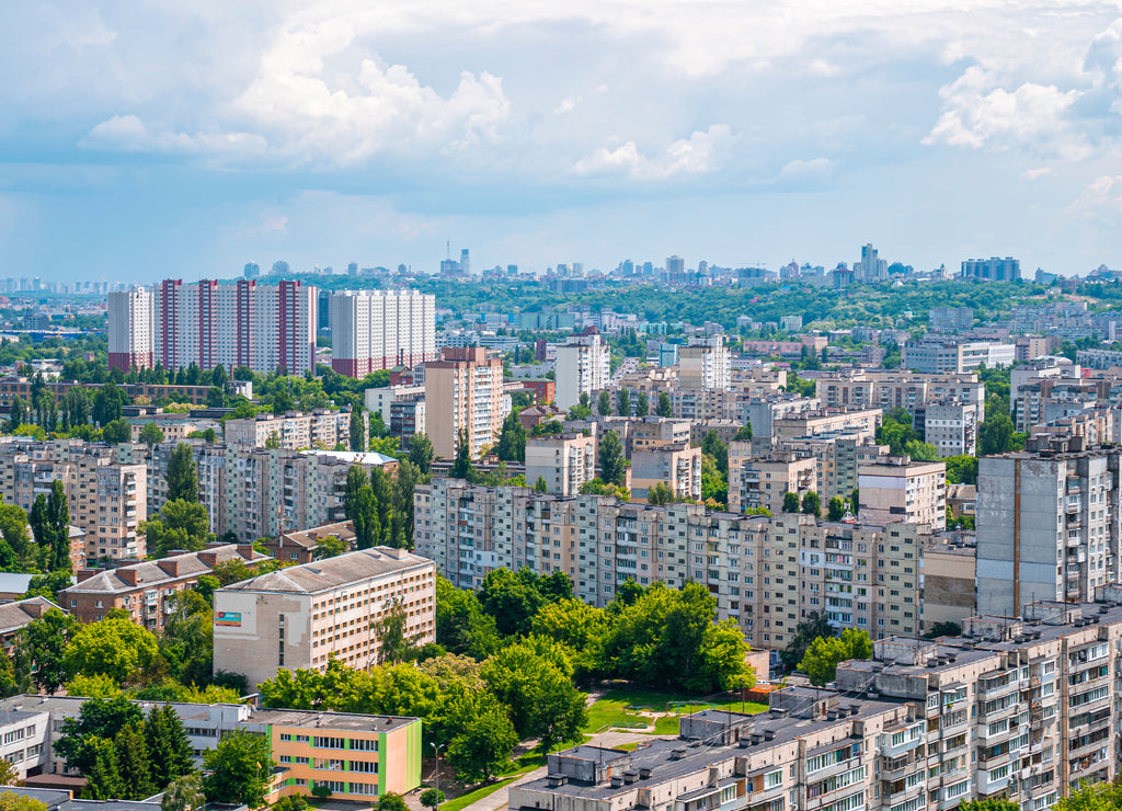 Scenic view of cityscape with green trees on sunny day against cloudy sky, Modern exterior of residential district of Kyiv in Ukraine