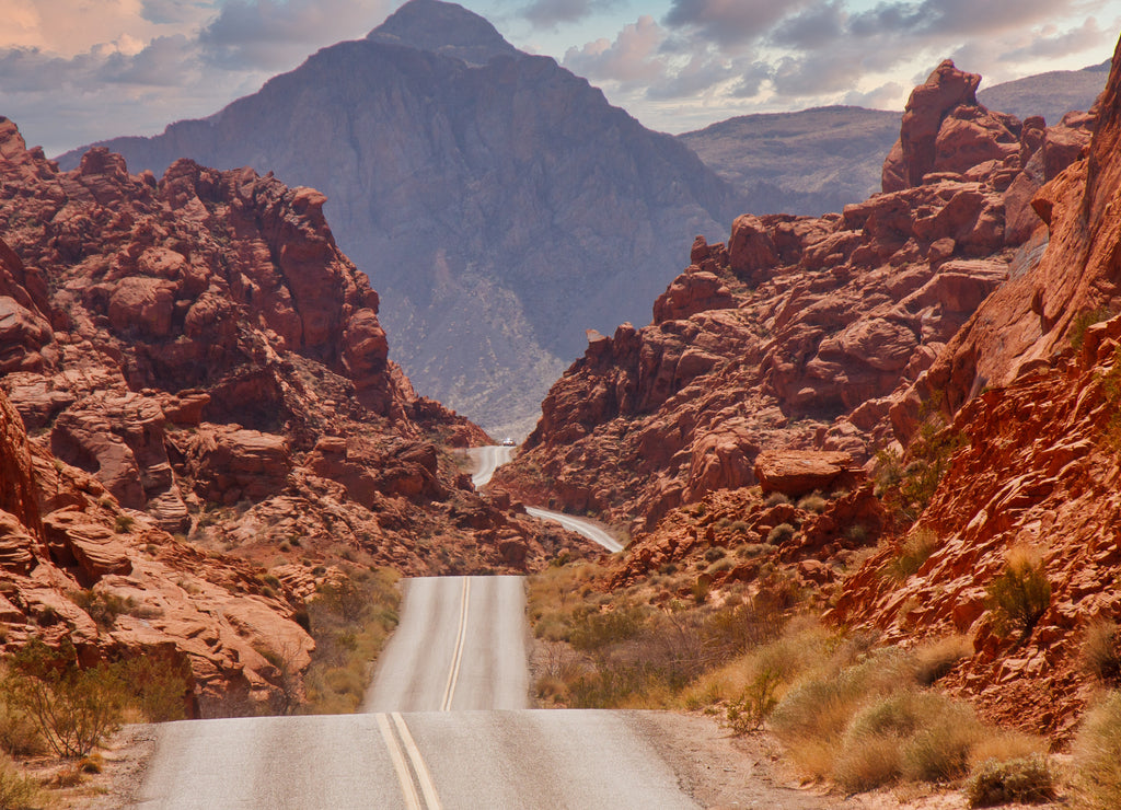 A highway rolling through red rock canyons in Nevada