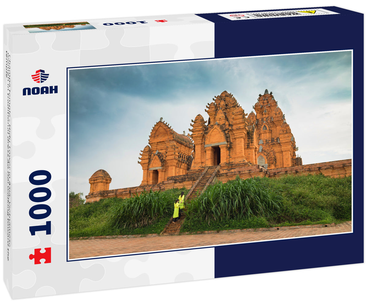 Champa temple - Hidu Tower in Asia. Vietnamese women in traditional dress Ao Dai walking toward the temple